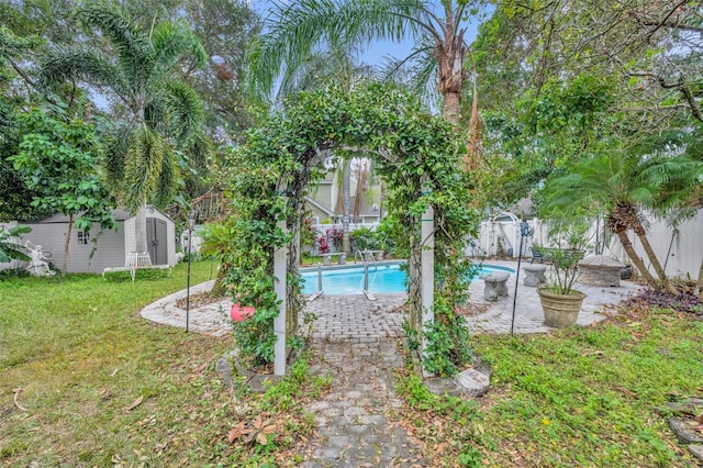 view of yard with a fenced in pool and a storage unit