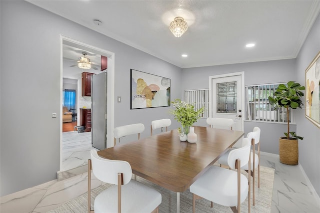 dining space featuring ceiling fan and crown molding