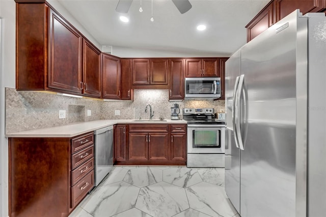 kitchen featuring lofted ceiling, sink, decorative backsplash, ceiling fan, and stainless steel appliances