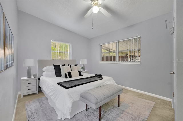 bedroom with light carpet, a textured ceiling, ceiling fan, and lofted ceiling