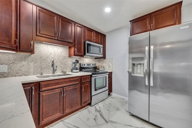 kitchen with decorative backsplash, sink, light stone countertops, and appliances with stainless steel finishes