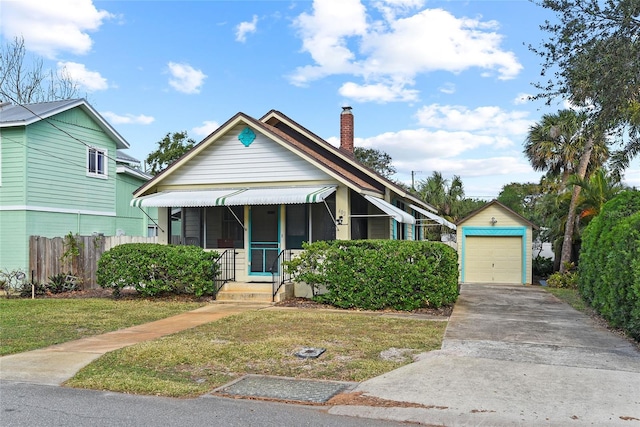 view of front of house with a garage, an outbuilding, and a front yard