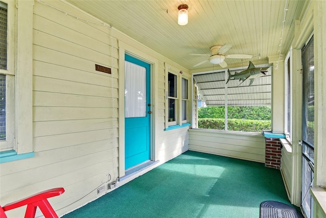 unfurnished sunroom with ceiling fan