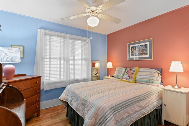 bedroom with ceiling fan and light hardwood / wood-style floors