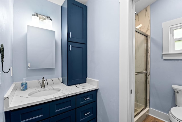 bathroom featuring vanity, toilet, and an enclosed shower