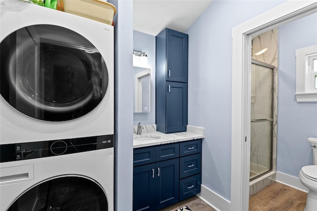 laundry area with dark hardwood / wood-style flooring, sink, and stacked washer and clothes dryer