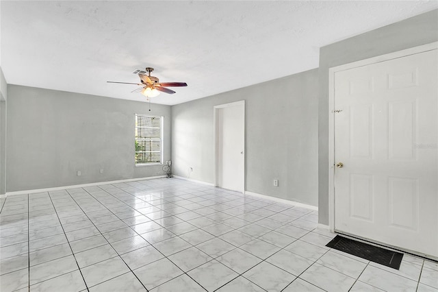 tiled spare room with ceiling fan