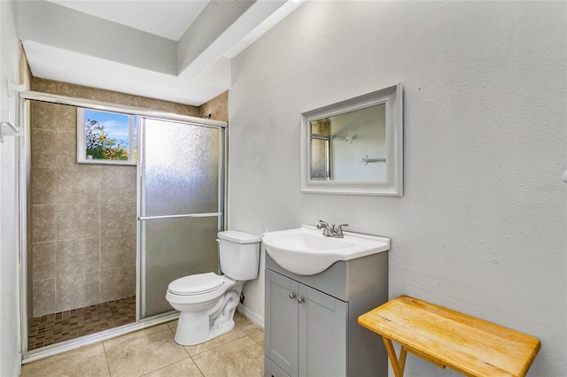 bathroom with a shower with shower door, tile patterned floors, toilet, and vanity