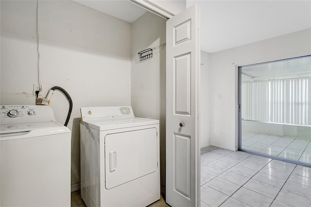 laundry area with independent washer and dryer and light tile patterned flooring