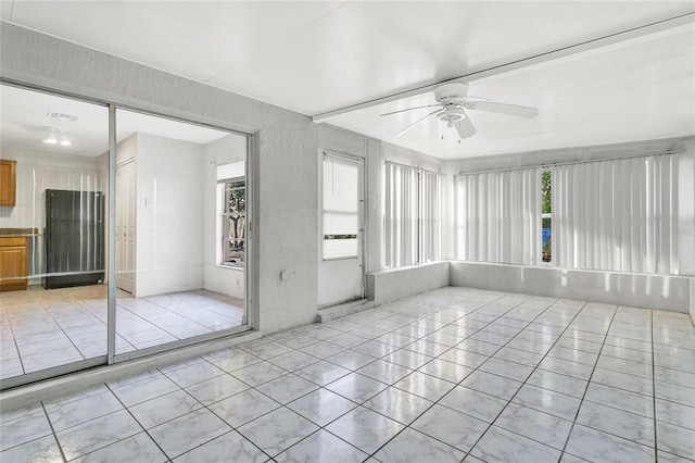 unfurnished sunroom with ceiling fan