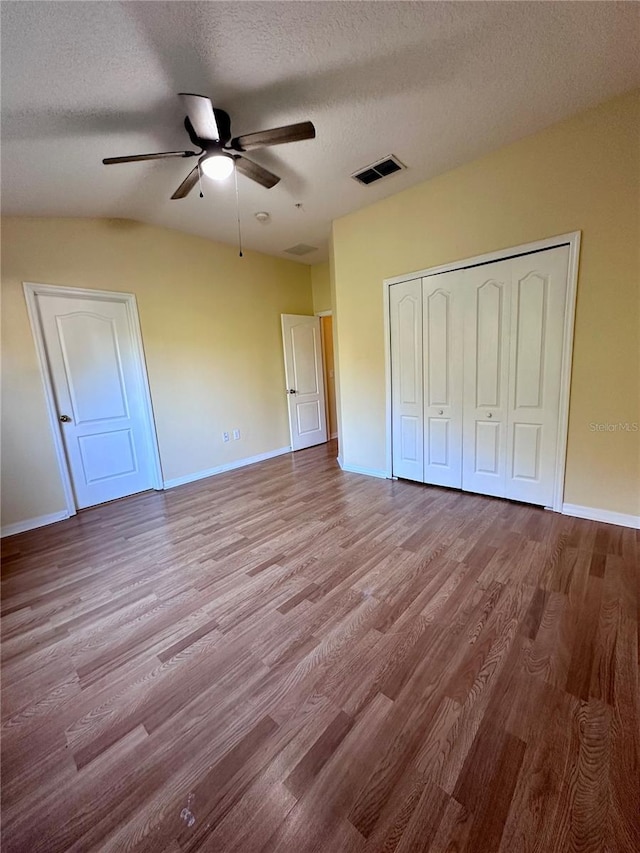 6430 S Goldenrod Rd Unit 15B, Orlando, FL 32822 - unfurnished bedroom featuring wood finished floors, a textured ceiling, baseboards, and a closet