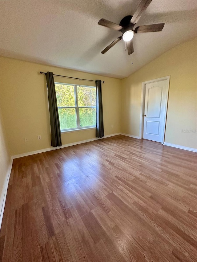 6430 S Goldenrod Rd Unit 15B, Orlando, FL 32822 - spare room featuring vaulted ceiling, a ceiling fan, wood finished floors, a textured ceiling, and baseboards