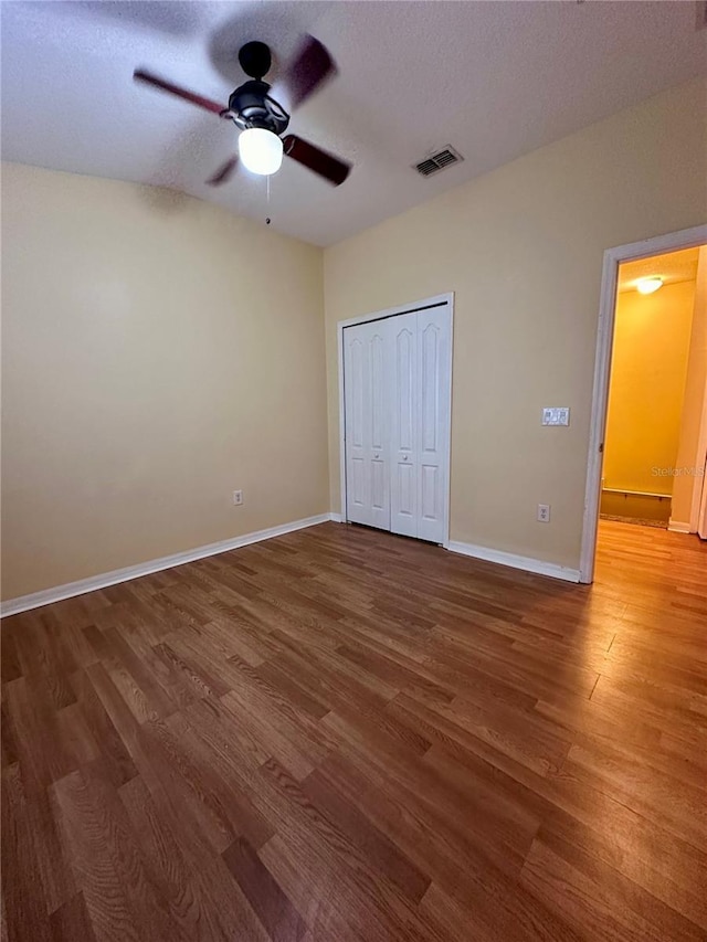 6430 S Goldenrod Rd Unit 15B, Orlando, FL 32822 - unfurnished bedroom featuring wood finished floors, baseboards, a closet, a textured ceiling, and ceiling fan