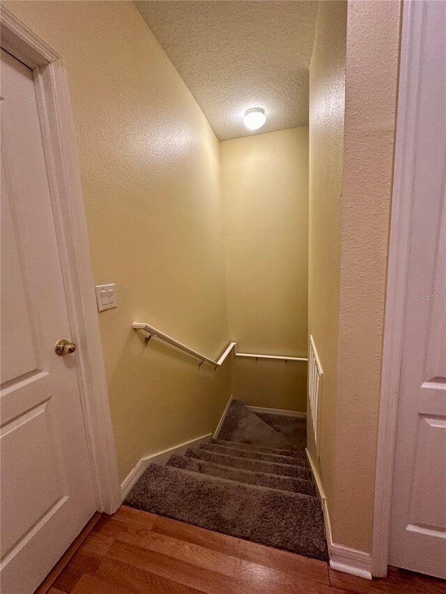 6430 S Goldenrod Rd Unit 15B, Orlando, FL 32822 - stairway with wood finished floors, a textured ceiling, and baseboards