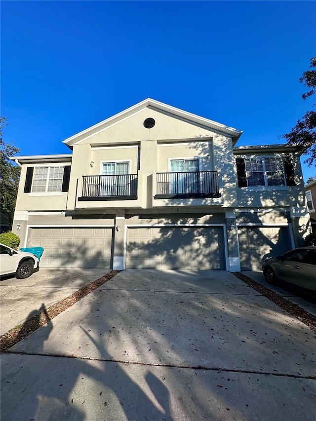 6430 S Goldenrod Rd Unit 15B, Orlando, FL 32822 - view of front of home featuring a garage, stucco siding, a balcony, and driveway