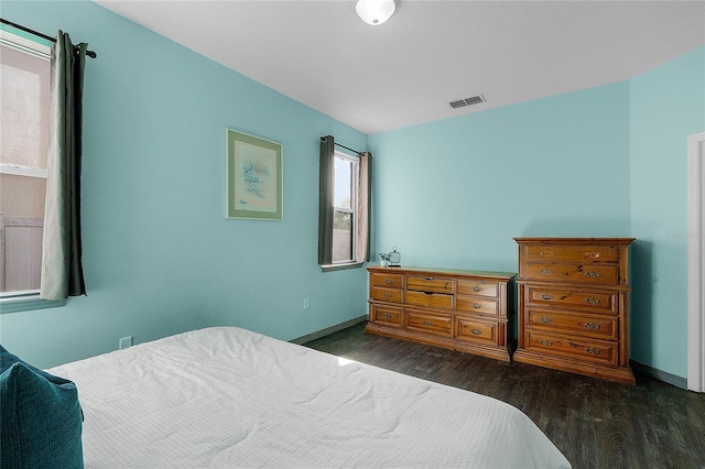 bedroom with dark hardwood / wood-style floors