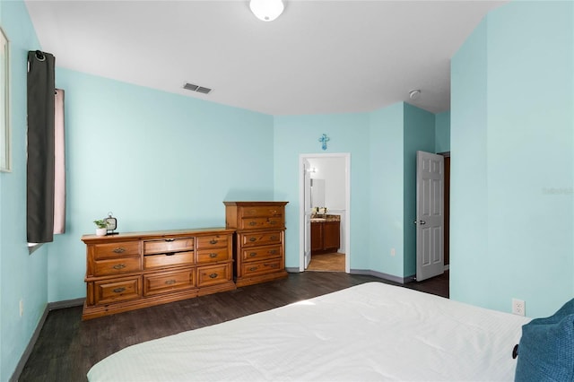 bedroom with dark hardwood / wood-style floors and connected bathroom