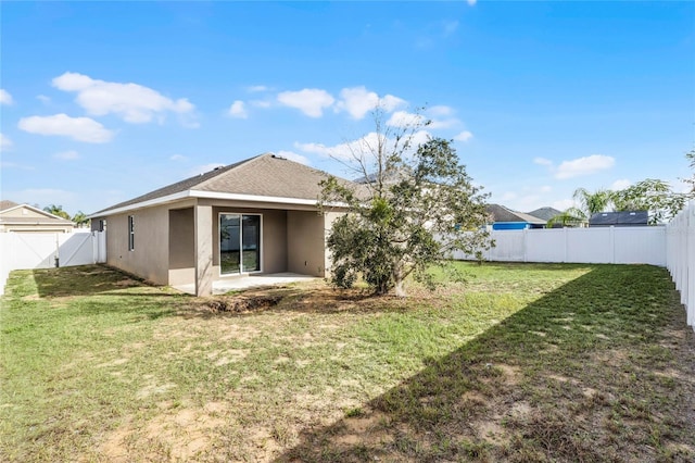 back of property with a yard and a patio area