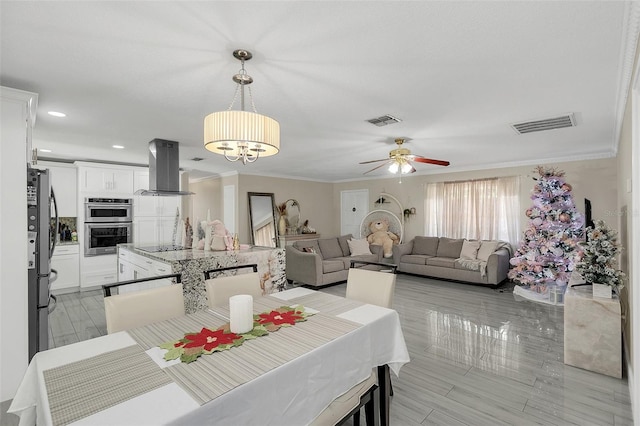 dining room featuring crown molding and ceiling fan with notable chandelier