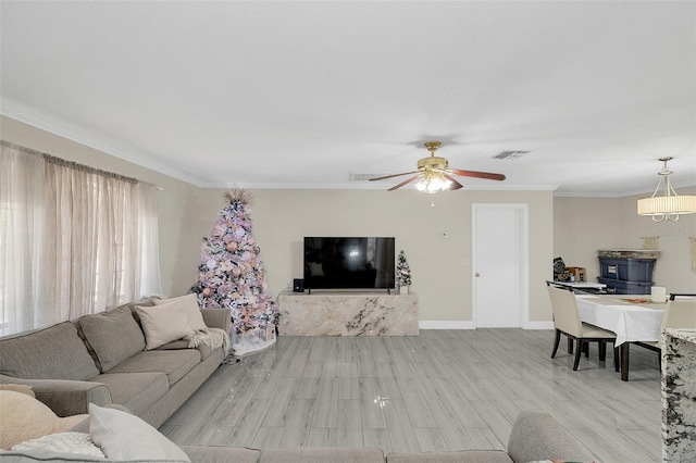 living room with light hardwood / wood-style floors, ceiling fan, and crown molding