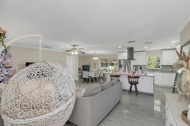 living room featuring ceiling fan and ornamental molding