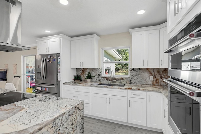 kitchen with sink, white cabinetry, and stainless steel refrigerator with ice dispenser