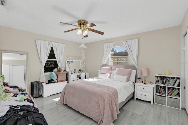 bedroom with ceiling fan and light hardwood / wood-style flooring