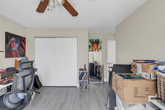 office featuring a textured ceiling, light hardwood / wood-style flooring, and ceiling fan