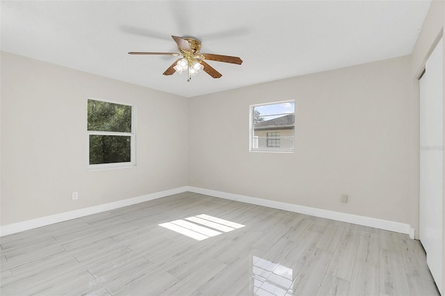 empty room with ceiling fan, plenty of natural light, and light hardwood / wood-style floors