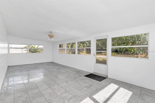 unfurnished sunroom with ceiling fan