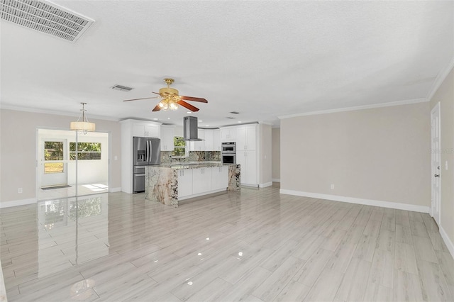 unfurnished living room with crown molding, a textured ceiling, ceiling fan, and light hardwood / wood-style flooring