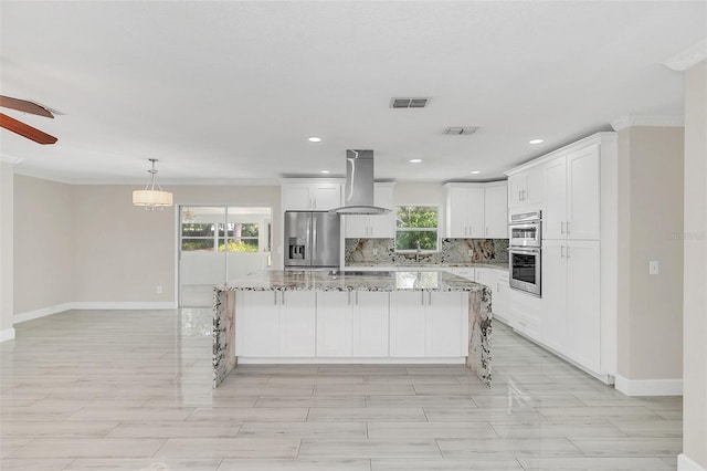 kitchen with island exhaust hood, stainless steel appliances, a kitchen island, and white cabinets