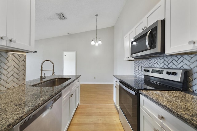 kitchen with visible vents, a sink, white cabinetry, appliances with stainless steel finishes, and light wood finished floors