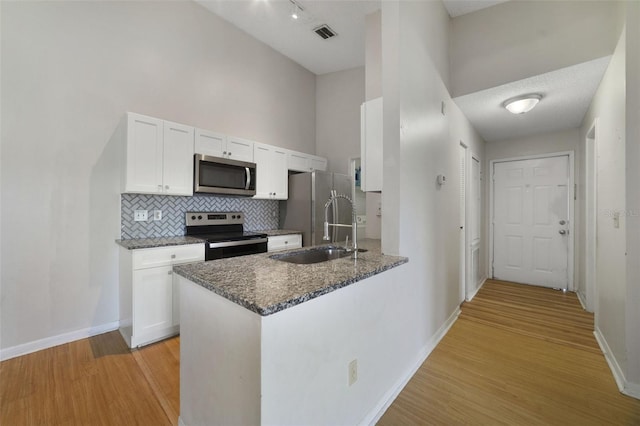 kitchen with visible vents, light wood finished floors, a sink, appliances with stainless steel finishes, and white cabinetry