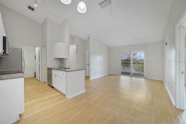 kitchen with visible vents, white cabinets, stainless steel appliances, and a sink