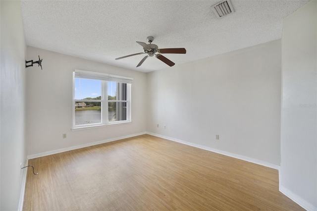 unfurnished room featuring visible vents, baseboards, ceiling fan, and wood finished floors