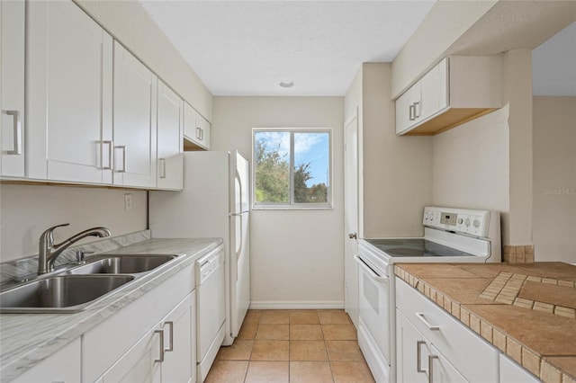 kitchen featuring white appliances, sink, light tile patterned floors, a textured ceiling, and white cabinetry