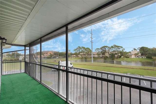 unfurnished sunroom featuring a water view