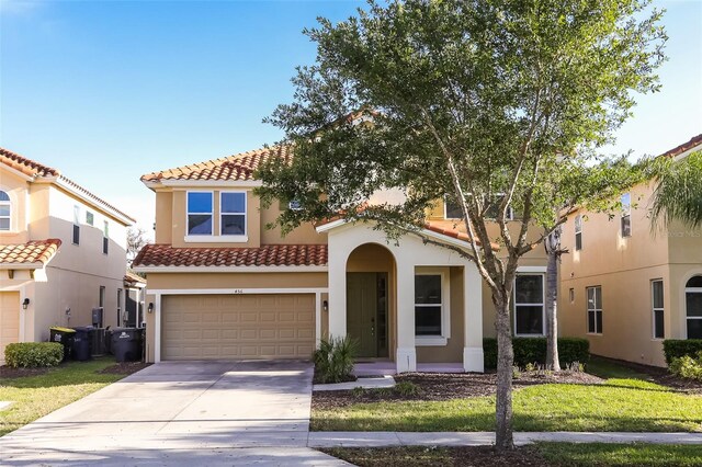 mediterranean / spanish home featuring a front lawn and a garage