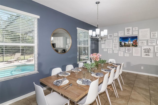 dining area with a chandelier and tile patterned floors