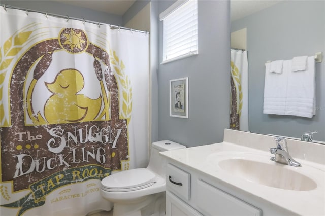 bathroom featuring curtained shower, vanity, and toilet