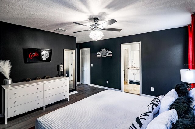 bedroom featuring a textured ceiling, dark hardwood / wood-style flooring, ceiling fan, and connected bathroom