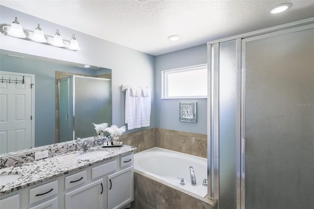 bathroom featuring vanity, separate shower and tub, and a textured ceiling