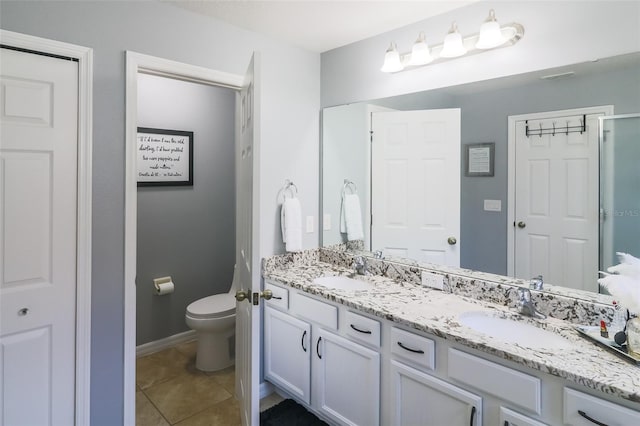 bathroom with tile patterned flooring, vanity, and toilet