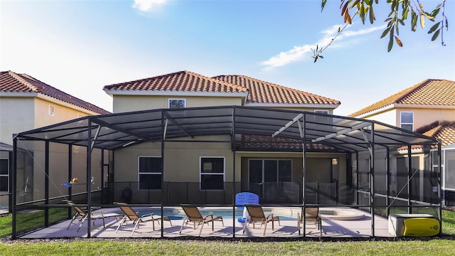 back of property featuring a lanai and a patio area