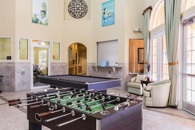 playroom featuring light tile patterned floors, a high ceiling, tile walls, and pool table