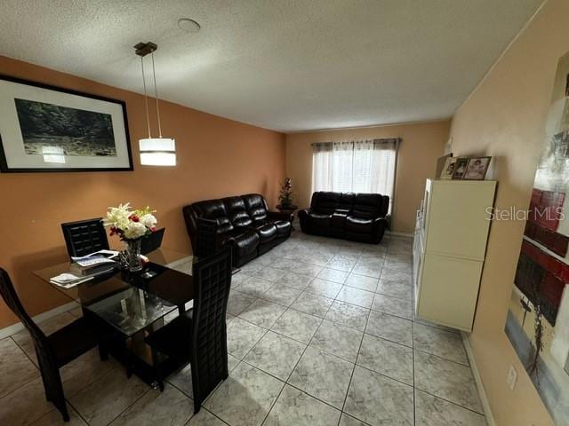 tiled dining room featuring a textured ceiling