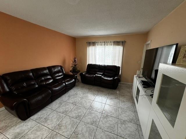 living room with light tile patterned floors and a textured ceiling