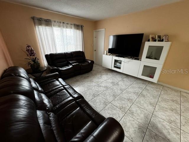 living room featuring tile patterned flooring and a textured ceiling