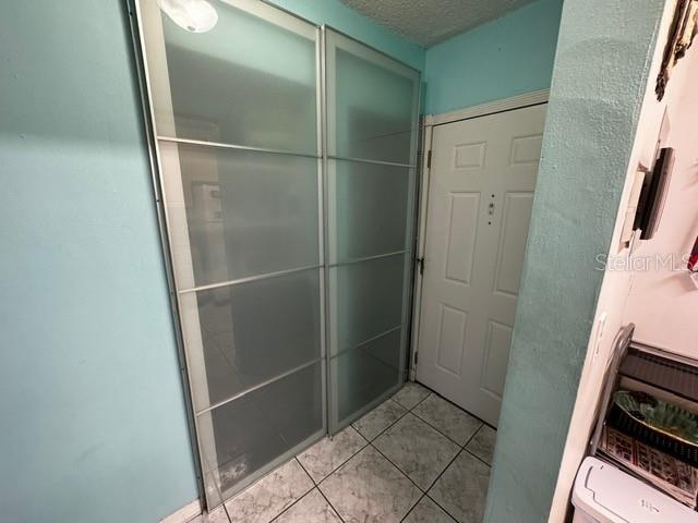 bathroom featuring tile patterned flooring and a textured ceiling